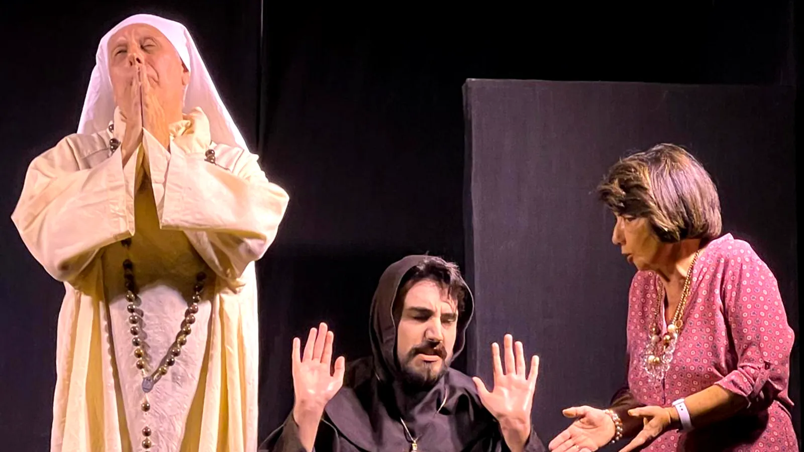 Attori di teatro in scena due uomini e una donna un uomo è vestito da suora, un uomo è vestito da monaco. Mentre la donna in abiti civili