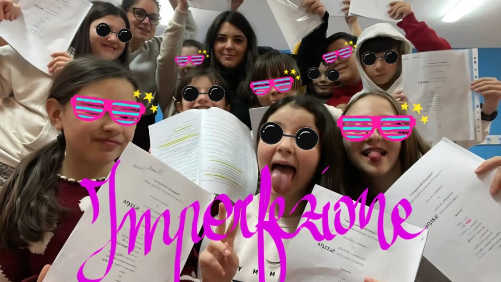 Un gruppo di sorridenti ragazzini e ragazzine tra 11 e 12 anni che tengono in alto il copione della drammaturgia che è stata scritta per loro