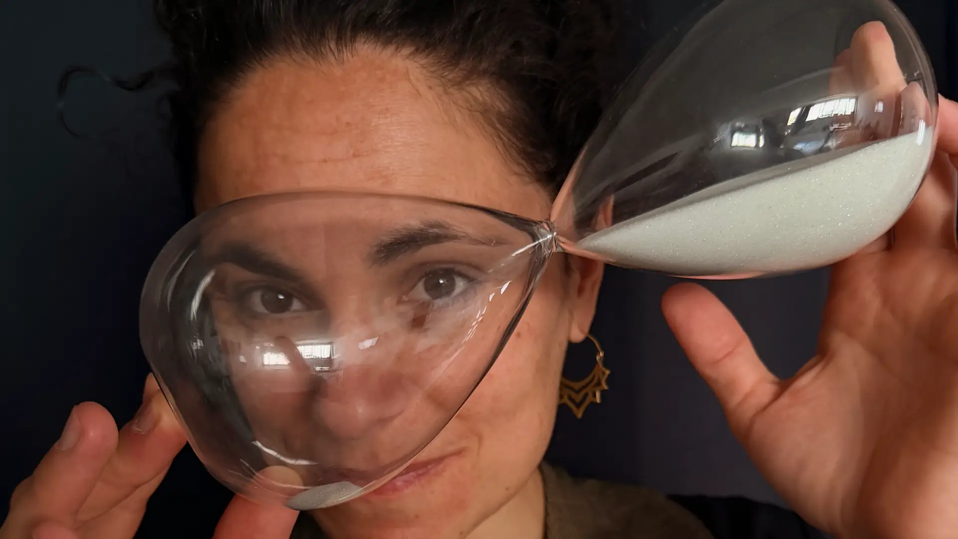 L'immagine descrive una drammaturga e pedagoga teatrale con in mano una classidra a sabbia: simboleggia la volontà di progettare con anticipo il lavoro di didattica e messa in scena di uno spettacolo con le proprie classi di teatro.
